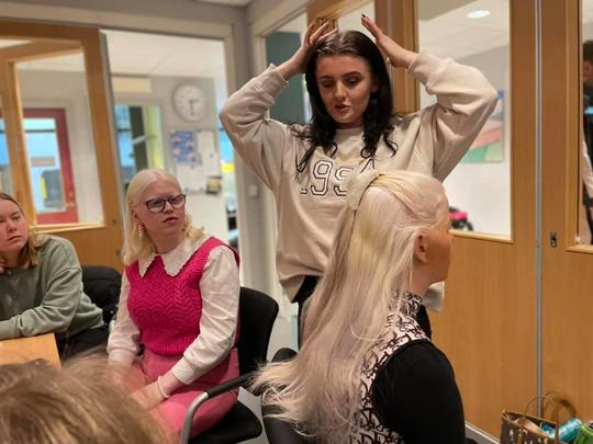 Kvinne som viser en annen kvinne hvordan sette opp håret. Foto: Vilde Adolfsen