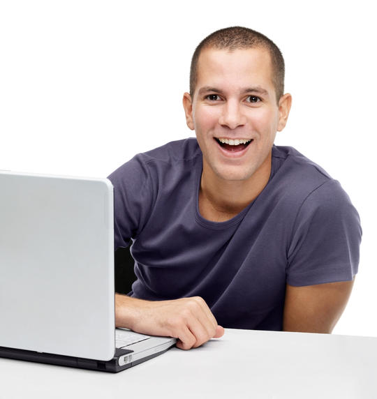 Ung mann med laptop og et fornøyd ansiktsuttrykk.